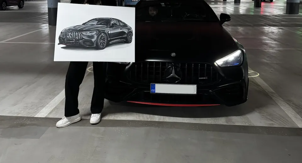 Žena drží obraz černého Mercedesu-AMG GT před skutečným vozem v garáži